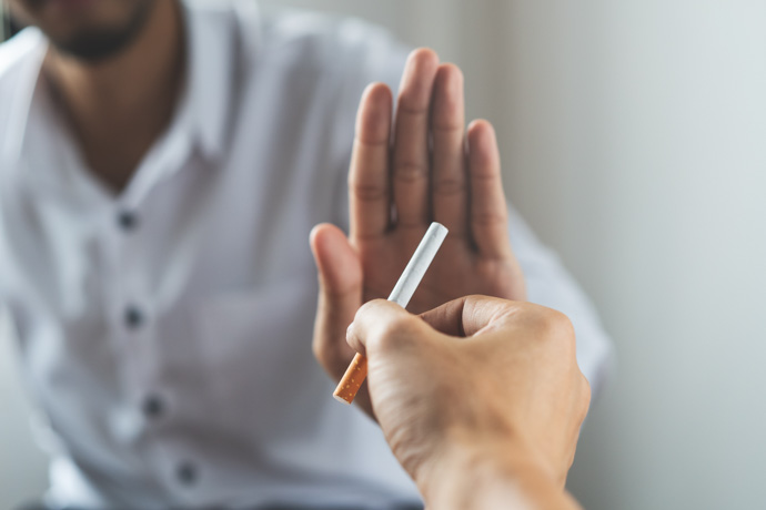Persona que rechaza un cigarrillo para no padecer los efectos del tabaco en la piel.
