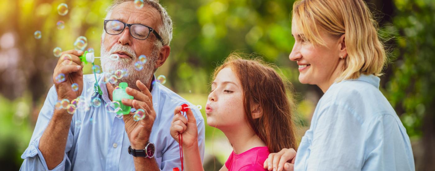 Familia jugando con burbujas en el parque