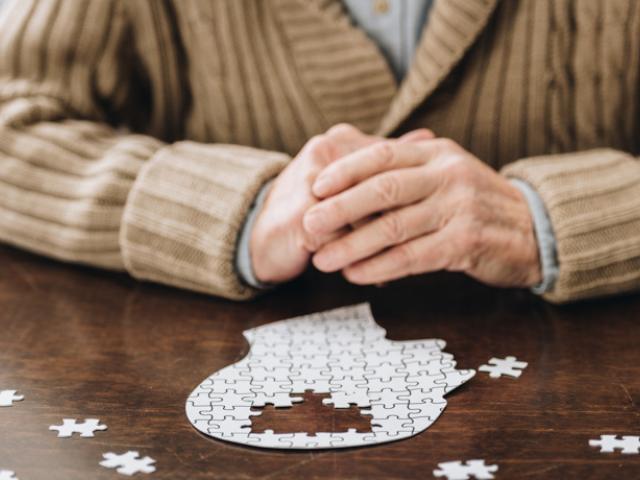 Hombre con deterioro cognitivo leve realizando un puzle. 