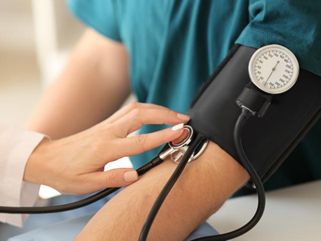 médico midiendo presión sanguínea