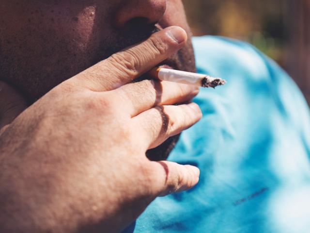 hombre con sobrepeso fumando